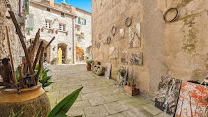 A narrow stone-paved alleyway with buildings on either side, some with balconies and potted plants. - Corte Paganini (Ricco del Golfo di Spezia)