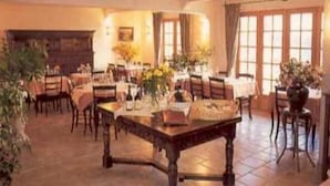 Un comedor con una amplia mesa de madera, varias sillas y una chimenea.