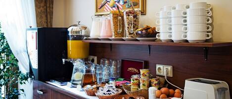 Un bufé de desayuno con diferentes alimentos, una máquina de café y un tostador.