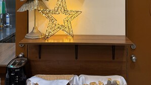 Une console en bois, agrémentée d’une horloge murale, d’une étoile décorative et d’un sapin de Noël.