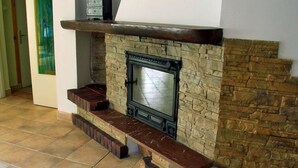 Une cheminée avec un foyer en pierre et une cheminée en bois.
