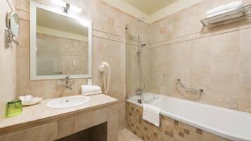 A bathroom with a sink, mirror, and bathtub.