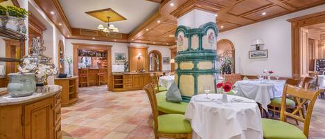 Un comedor amplio con muebles de madera y manteles blancos.