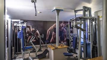 A gym with various exercise equipment, including weight machines and benches.