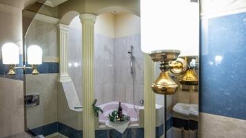 A bathroom with a bathtub, a shower, and a sink. There are mirrors and a towel rack.