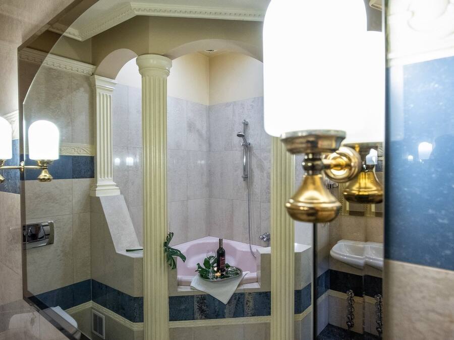 A bathroom with a bathtub, a shower, and a sink. There are mirrors and a towel rack.