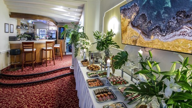 Ein reichhaltiges Buffet mit verschiedenen Speisen, eine Bar und ein großes Gemälde an der Wand.