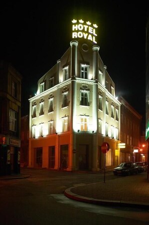 Un hotel con un llamativo letrero iluminado que dice "HOTEL ROYAL".
