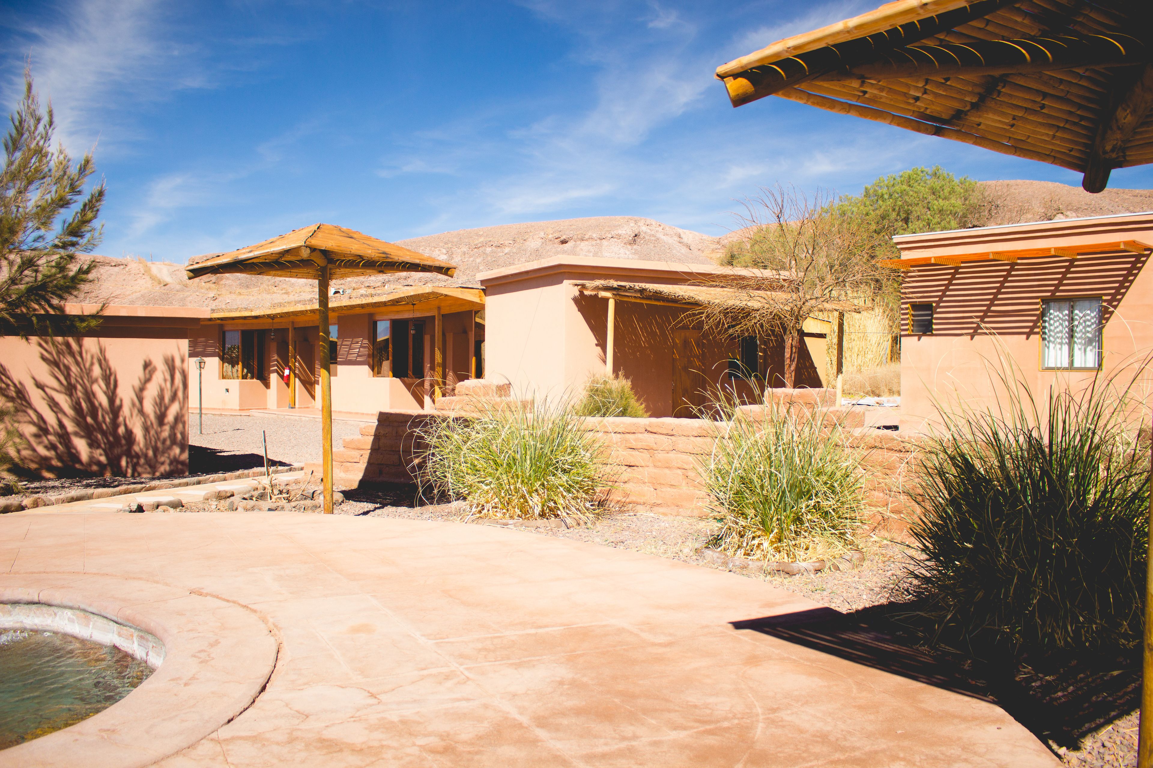 A courtyard with a pool, a gazebo, and a building with a flat roof.