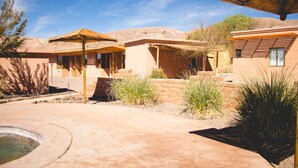 A courtyard with a pool, a gazebo, and a building with a flat roof. - Hotel Iorana Tolache (San Pedro de Atacama)