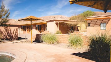 A courtyard with a pool, a gazebo, and a building with a flat roof.