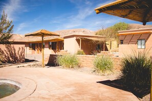 Un patio con piscina, un pabellón y un edificio de techo plano.