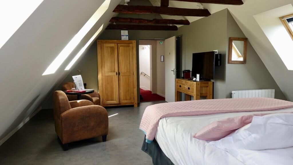 Een slaapkamer met een bed, een bureau, een stoel, een kledingkast en een televisie.