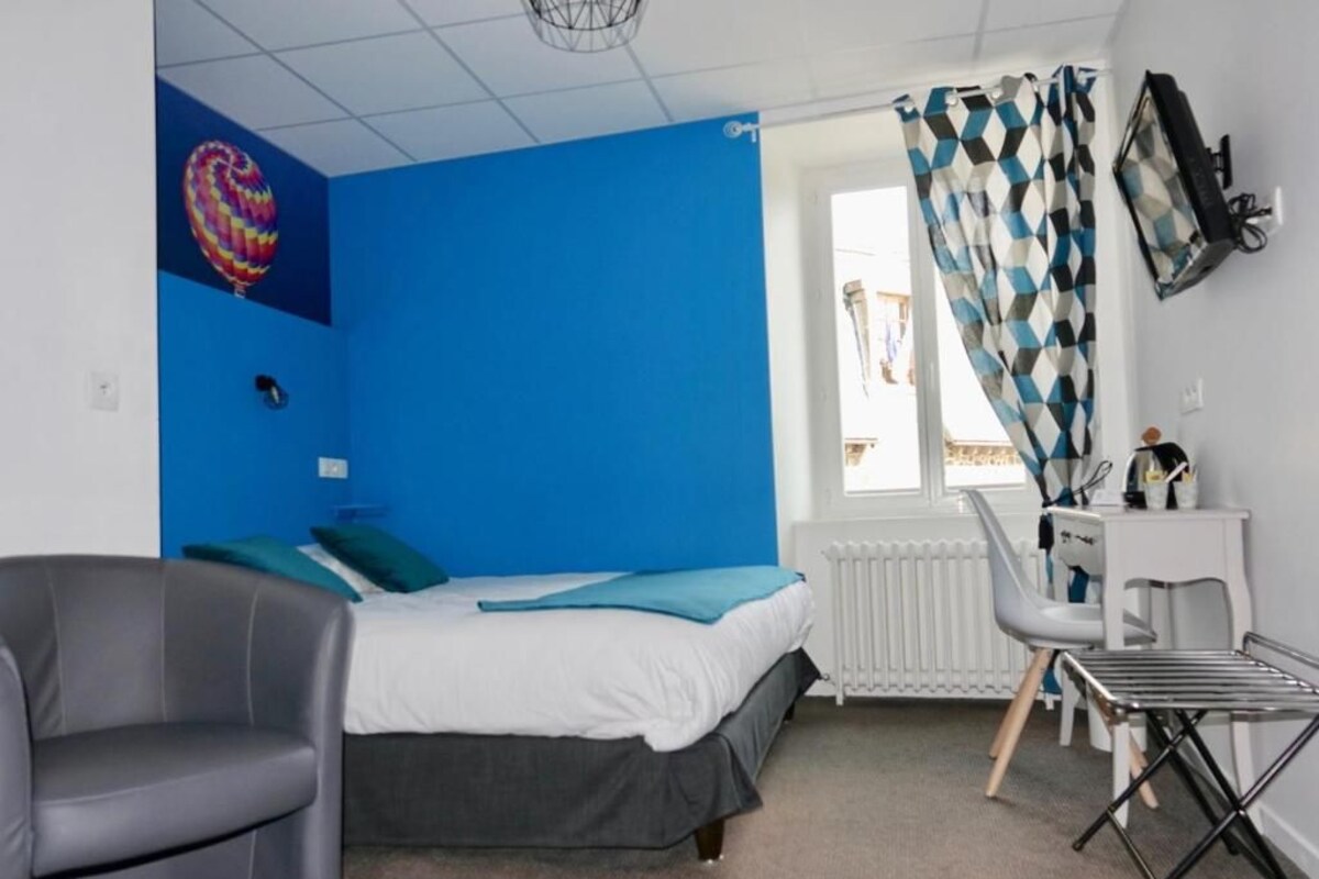 A room with a bed, a desk, a chair, and a radiator.