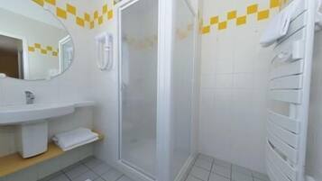 Un baño con ducha, lavamanos y espejo.