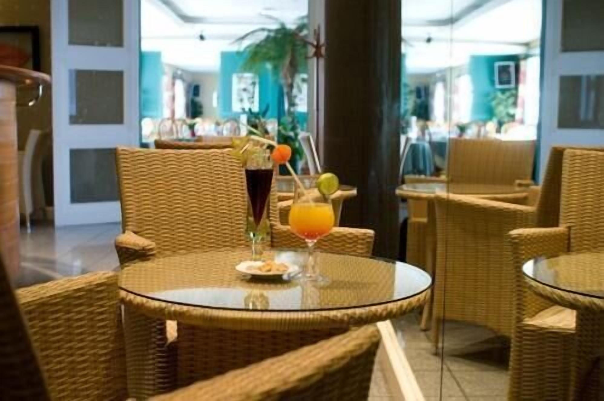A hotel room with wicker furniture and a glass table.