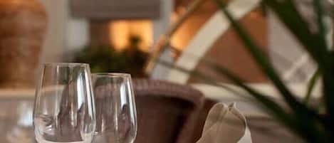 A room with a sofa and two empty wine glasses on a table.