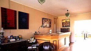 Een kamer met een houten bureau, een lederen stoel en kunst aan de wanden.