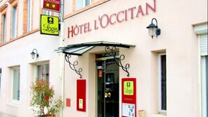 The exterior of Hotel L'Ocitan with a clear entrance, a potted plant, and a sign for Logis parking. - Hôtel l'Occitan (Gaillac)