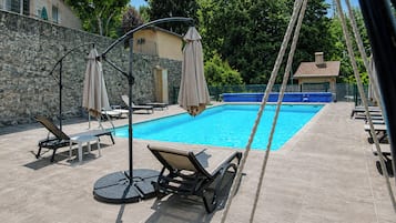 Piscine extérieure, parasols de plage, chaises longues