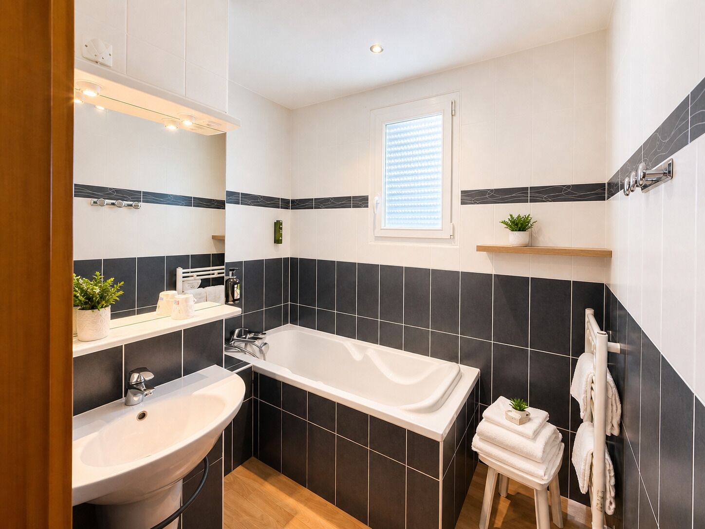 Un baño moderno con bañera, lavamanos y ventana.