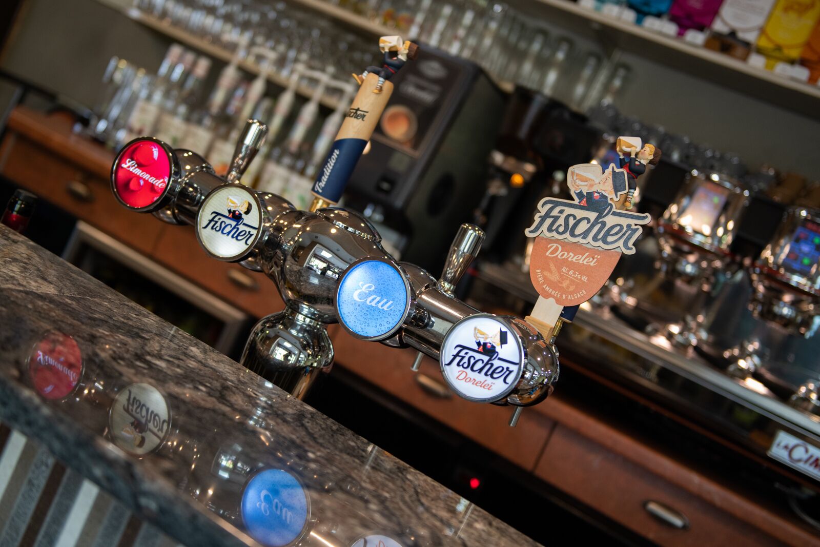 Un bar con varias griferías de cerveza, incluyendo marcas como Fischer y Dorelei.