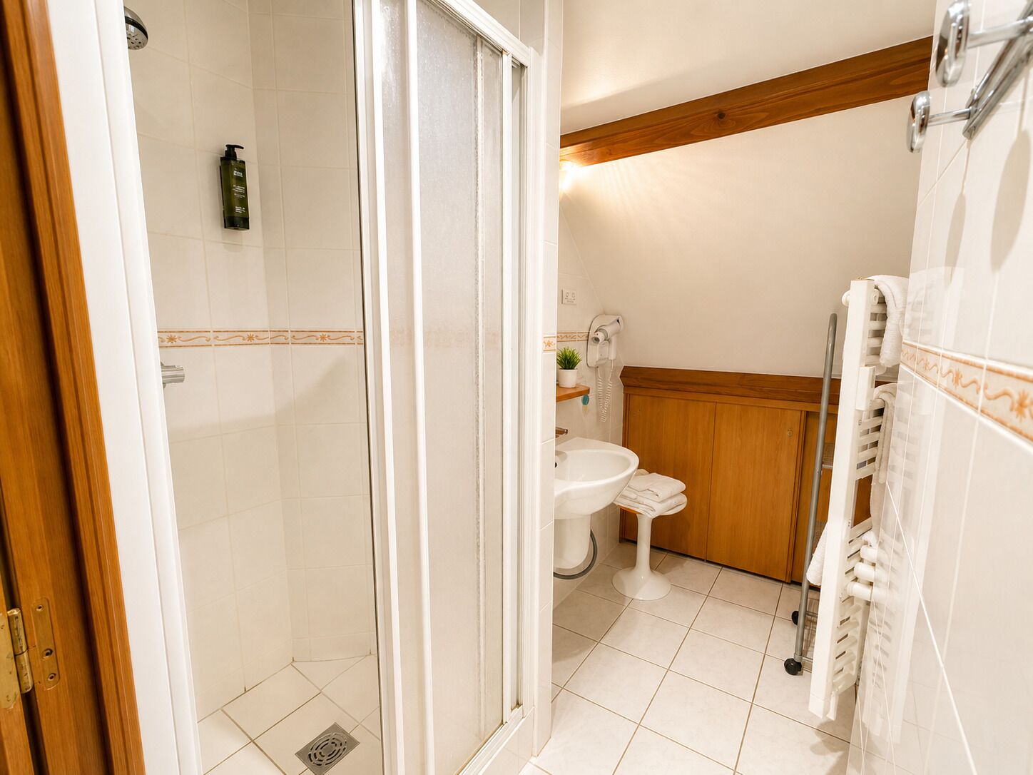 Ein Badezimmer mit Dusche, Toilette, Waschbecken und Handtuchhalter.
