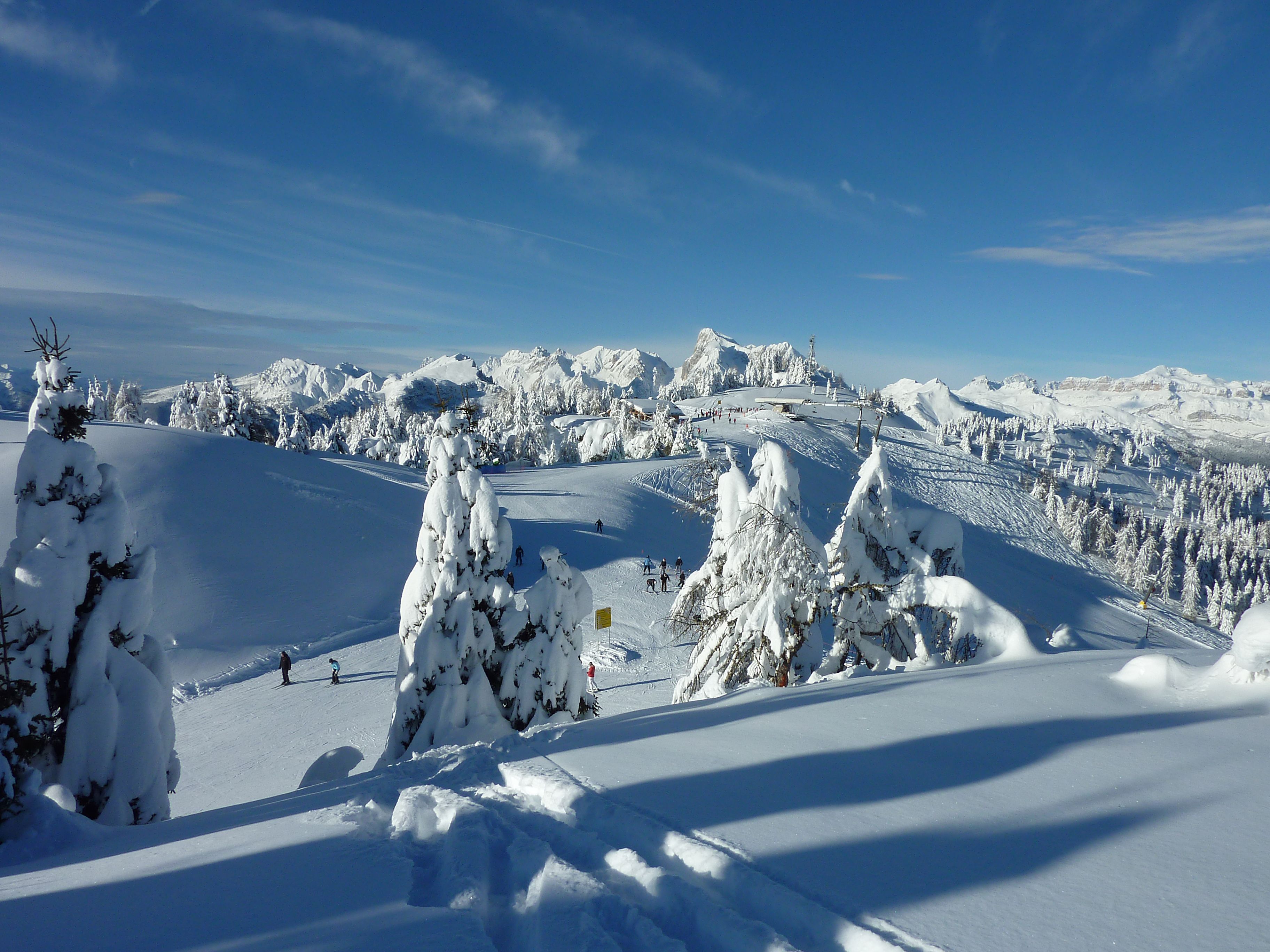 A snow-covered mountain landscape with ski slopes and trees.