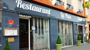 Ein Restaurant namens 'La Paix' mit einem gut sichtbaren Eingang und einer Beschilderung.