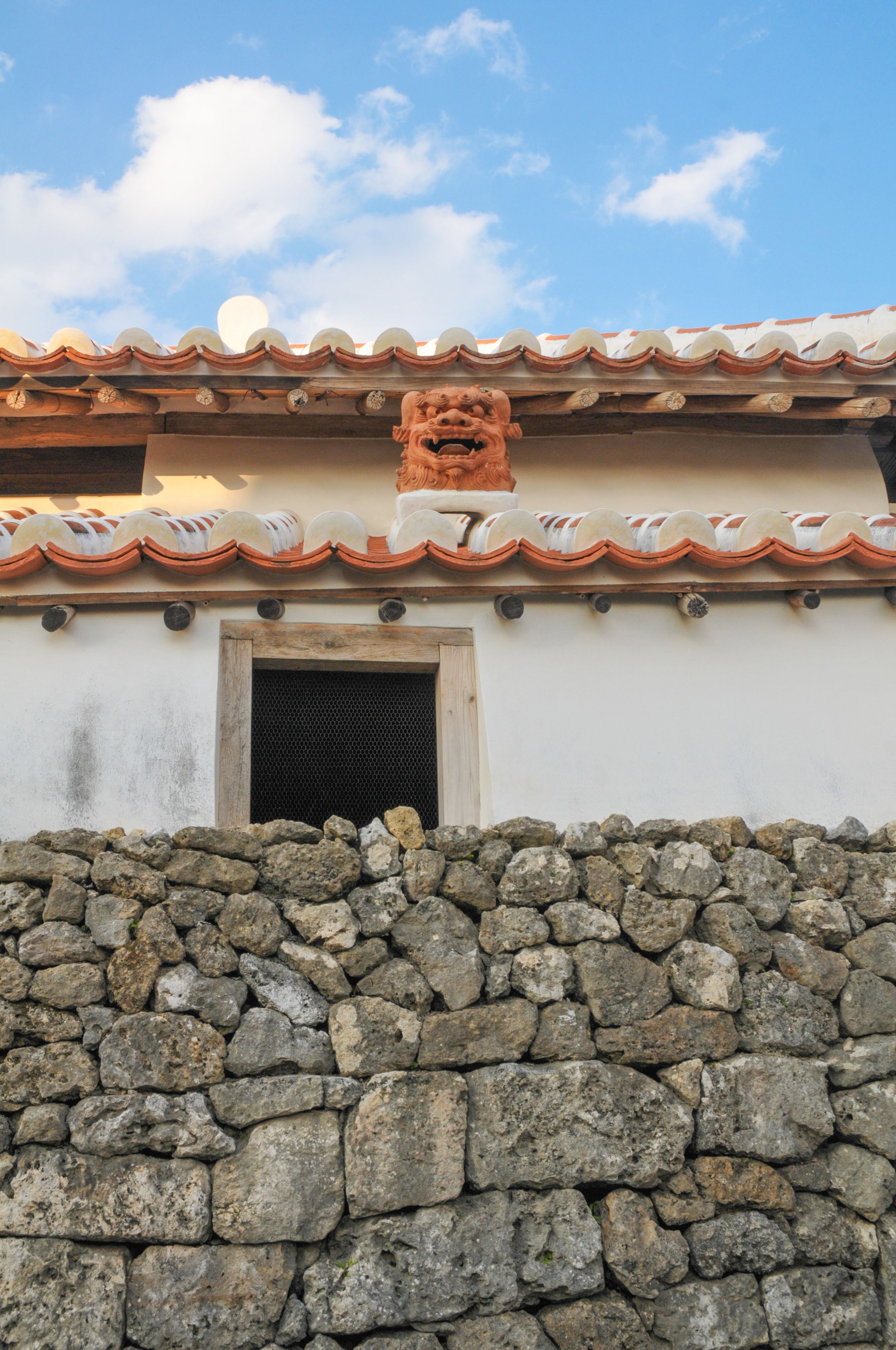 A stone wall, a tiled roof, and a small window.