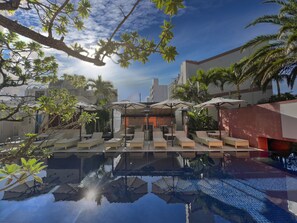 A rooftop pool area with lounge chairs and umbrellas, surrounded by palm trees and buildings. - Hotel Palm Royal Resort Kokusai Street (Naha)