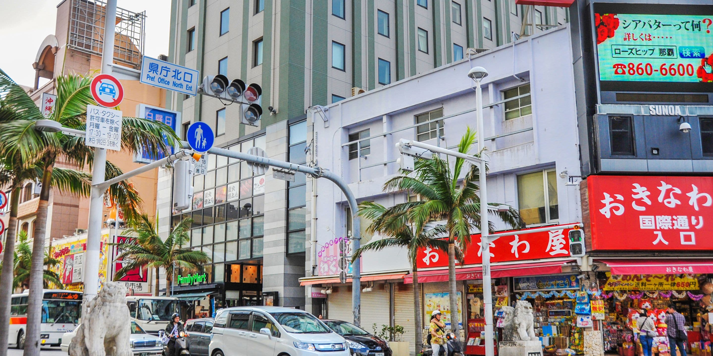 A busy urban street with various shops, including a red storefront with Japanese signage.