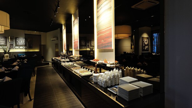 A buffet area with multiple food stations, a long counter, and seating arrangements. - Abell Hotel Kuching (Kuching)