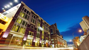 A multi-story hotel with a modern facade, large windows, and illuminated signage. - Abell Hotel Kuching (Kuching)