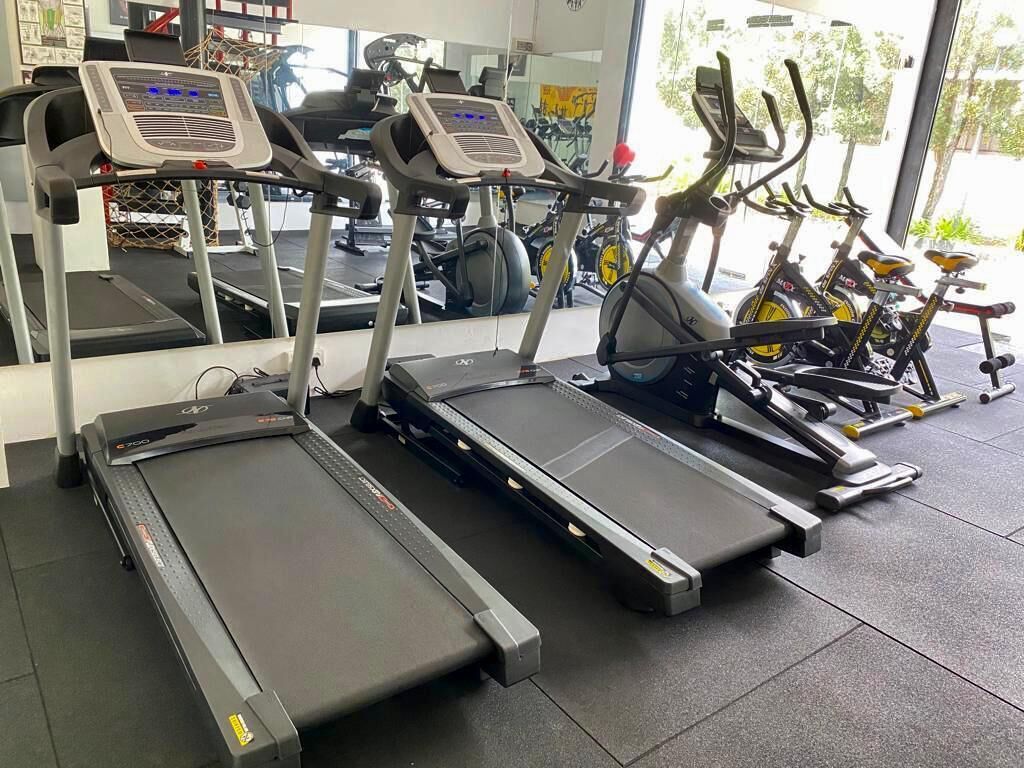 A gym with treadmills, stationary bikes, and exercise equipment.