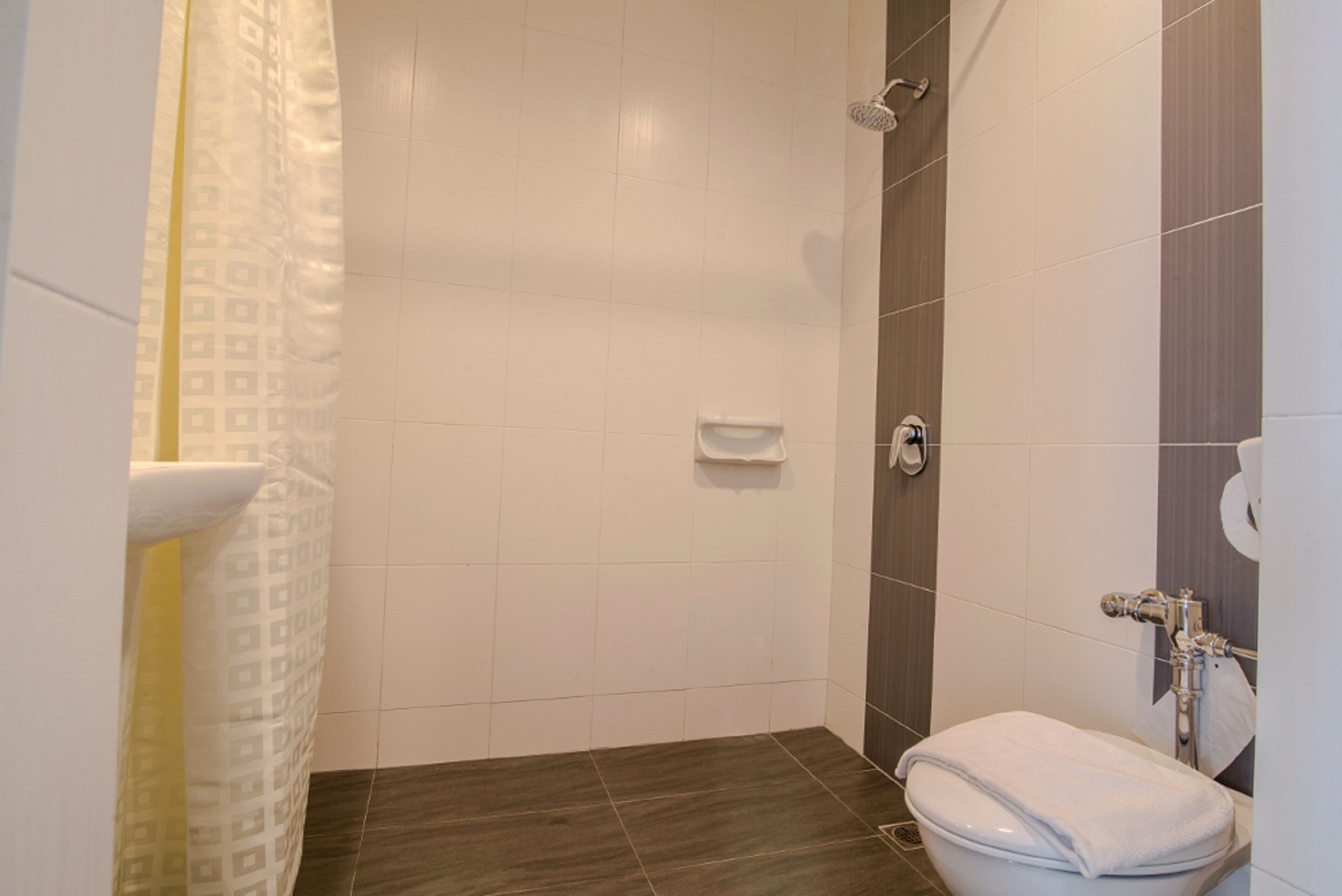 A bathroom with a shower, toilet, and sink.