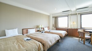 A hotel room with two beds, a desk, and a chair.