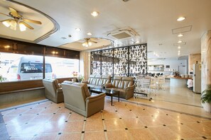 A hotel lobby with seating areas, a reception desk, and a view of the street. - Hotel Sun Plus Yutaka (Izumisano)