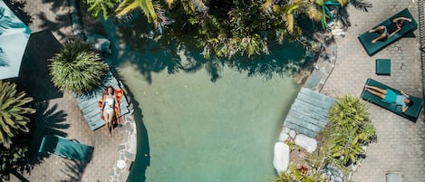 Una piscina al aire libre, tumbonas