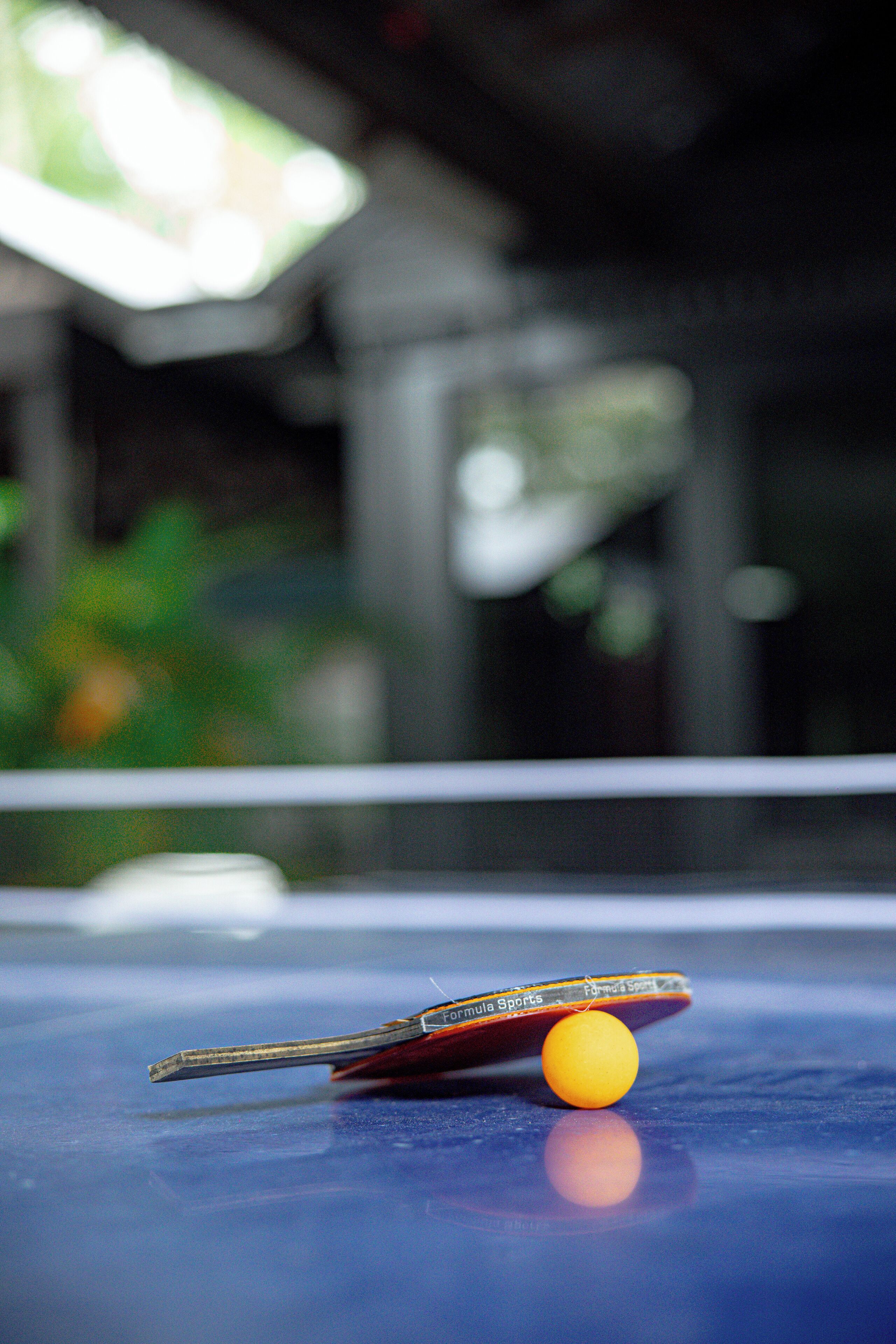 A close-up of a table tennis table with a paddle and ball.