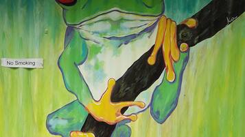 A painting of a frog on a branch with a "No Smoking" sign.