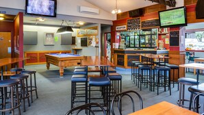 A bar area with a pool table, stools, and a reception desk. - Ocean Beach Hotel (Dunedin)