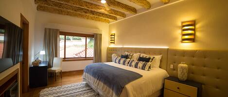 Un dormitorio con una cama grande, una mesita de noche, un televisor y un ventilador de techo.