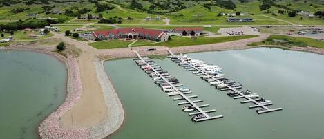 An aerial view of a marina with multiple docks and a large building in the background.