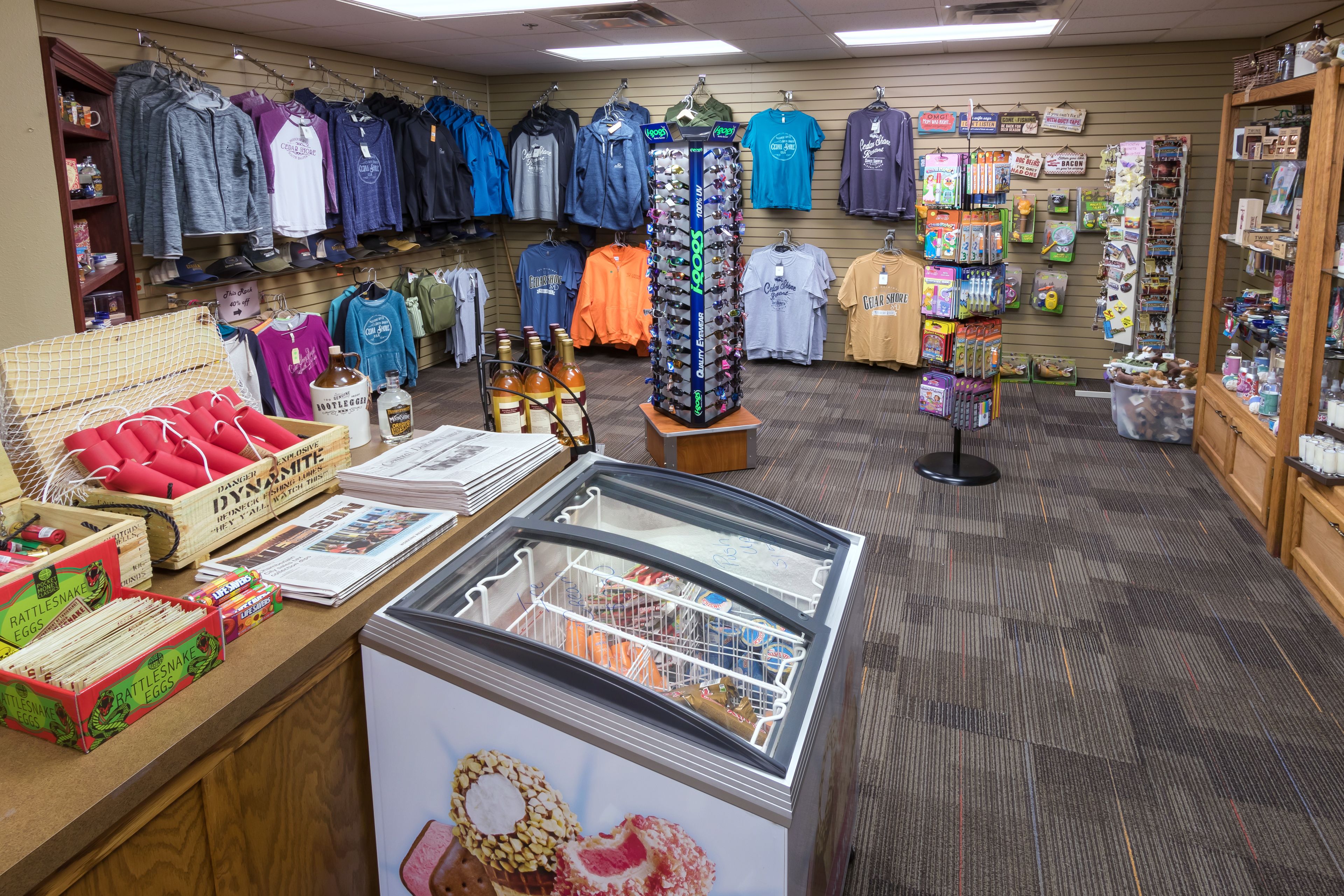 A retail store with clothing racks, a display case, and various merchandise.