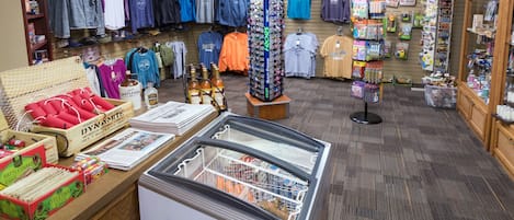 A retail store with clothing racks, a display case, and various merchandise.