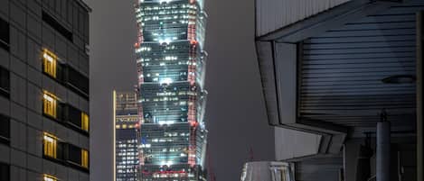 Un edificio alto con ventanas iluminadas y un letrero que dice 'AURORA' al frente.
