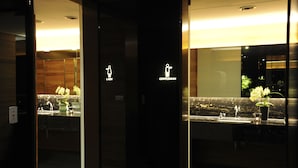 A hotel lobby with a reception desk, a marble counter, and a glass door with "LADY" and "GENTLEMAN" signs.