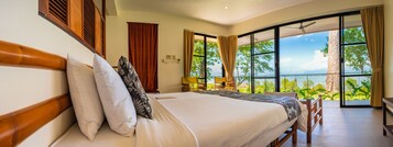 Una habitación de hotel con una cama grande, vistas al exterior y un balcón.