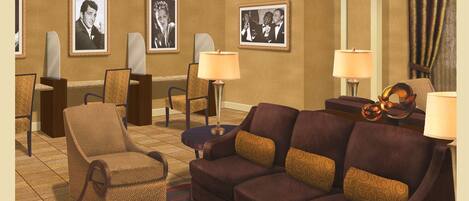 A hotel lobby with a brown sofa, armchairs, a coffee table, and framed pictures on the walls.
